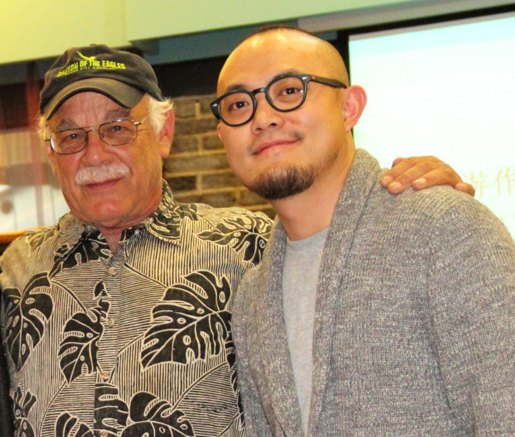 Mo Mao (right) and Tom Wilmer visit at a symposium in Chengdu, China